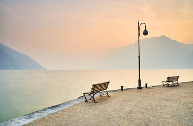Italy, Torbole, empty benches at Lake Garda in winter - MRF01937