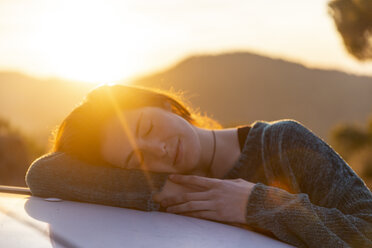 Young woman on a road trip, taking a break, resting on car - AFVF02490