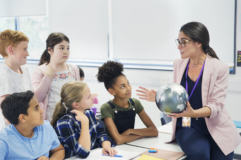 Aufmerksame Gymnasiasten beobachten Geografielehrer mit Globus - CAIF22915