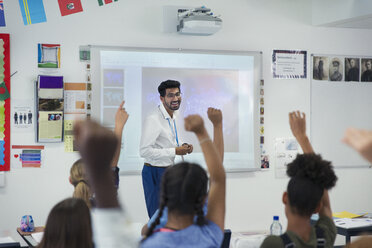 Lächelnder männlicher Lehrer, der den Unterricht im Klassenzimmer leitet - CAIF22918