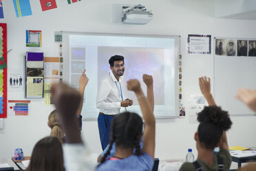 Smiling male teacher leading lesson in classroom - CAIF22918