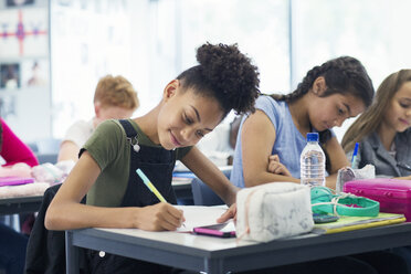 Selbstbewusste Junior High School-Schülerin bei den Hausaufgaben im Klassenzimmer - CAIF22919