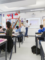 Male teacher leading lesson at projection screen in classroom - CAIF22923