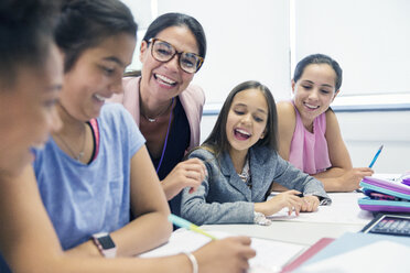 Enthusiastic female teacher and junior high school girl students in classroom - CAIF22930