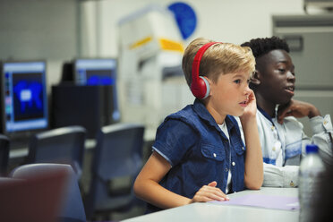 Konzentrierter Junge der Junior High School mit Kopfhörern im Klassenzimmer - CAIF22941