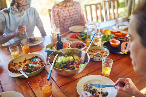 Freunde essen eine gesunde Mahlzeit während eines Yoga-Retreats, lizenzfreies Stockfoto