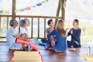 Yogaklasse im Kreis in einer Hütte während eines Yoga-Retreats - CAIF22973