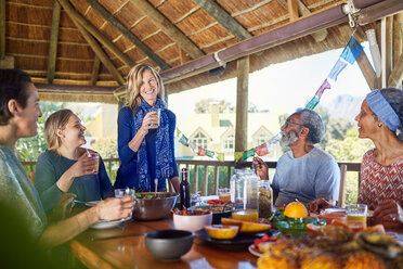 Freunde genießen eine gesunde Mahlzeit in einer Hütte während eines Yoga-Retreats - CAIF22982