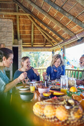 Freunde genießen eine gesunde Mahlzeit in einer Hütte während eines Yoga-Retreats - CAIF23005