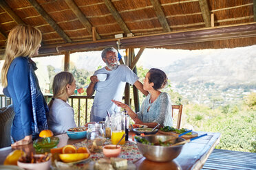 Freunde genießen eine gesunde Mahlzeit in einer Hütte während eines Yoga-Retreats - CAIF23019