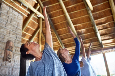 Frauen üben Yoga während eines Retreats in einer Hütte - CAIF23020