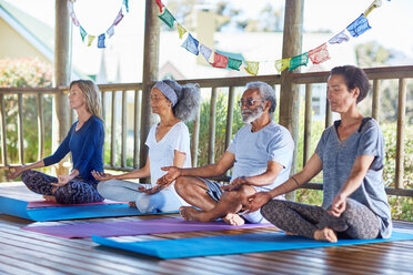 Gelassene Menschen meditieren in einer Hütte während eines Yoga-Retreats - CAIF23031