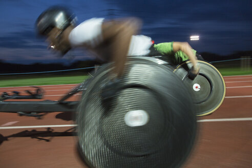 Querschnittsgelähmte Athleten rasen bei einem nächtlichen Rollstuhlrennen über eine Sportstrecke - CAIF23040