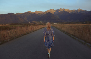USA, Kalifornien, Rückenansicht einer erdbeerblonden Frau auf einer Landstraße - AZF00131