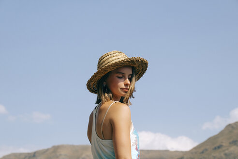 Seitenansicht einer Frau mit geschlossenen Augen und Hut vor blauem Himmel an einem sonnigen Tag - CAVF61885