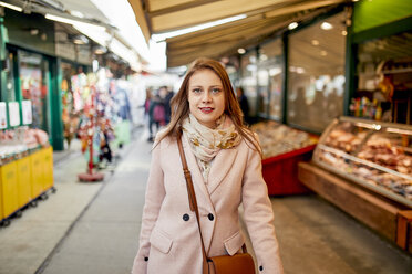 Österreich, Wien, Porträt einer lächelnden jungen Frau beim Einkaufen am Naschmarkt - ZEDF01930