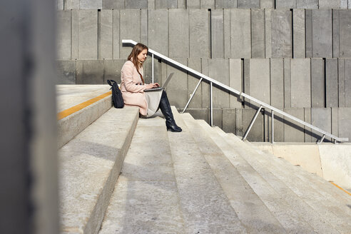 Österreich, Wien, junge Frau sitzt auf einer Treppe im MuseumsQuartier und benutzt einen Laptop - ZEDF01933