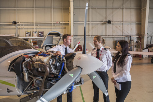 Ingenieur zeigt Auszubildenden in einem Hangar Flugzeugteile - CAVF62048