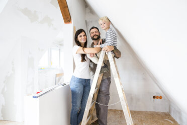 Porträt einer glücklichen Familie beim Ausbau des Dachbodens - MFRF01178