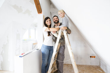 Portrait of happy family working on loft conversion - MFRF01178