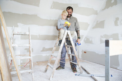 Vater und Sohn arbeiten am Dachbodenausbau - MFRF01189
