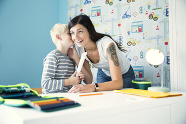Mutter hilft Sohn bei den Hausaufgaben am Schreibtisch - MFRF01224