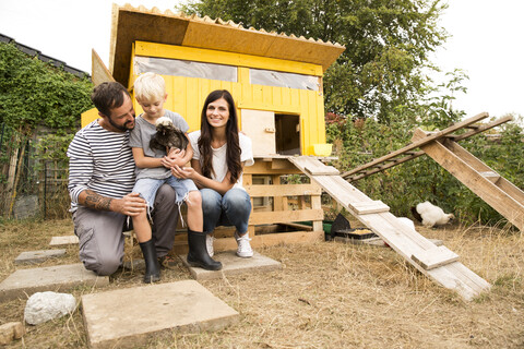 Portrait of happy family with Polish chicken at chickenhouse in garden stock photo