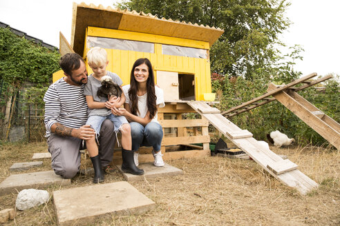 Porträt einer glücklichen Familie mit polnischen Hühnern im Hühnerstall im Garten - MFRF01251