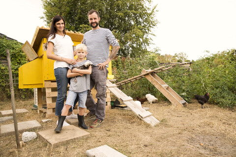 Porträt einer selbstbewussten Familie mit polnischen Hühnern im Hühnerstall im Garten, lizenzfreies Stockfoto