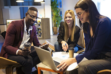 Business people sitting in a hotel lobby, working together - JSRF00169