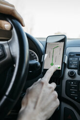 Close-up of woman driving in a car using a telephone navigation app - JRFF02797