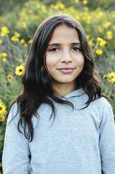 Close-up portrait of smiling girl standing amidst plants during sunset - CAVF62088