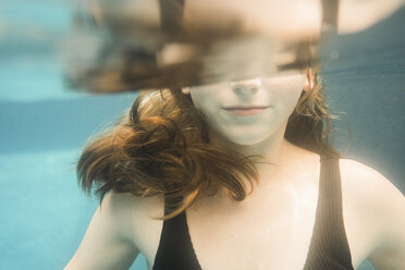 Midsection of girl swimming underwater in lake - CAVF62164
