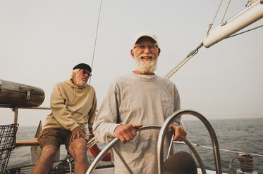 Portrait of senior man with friend sailing boat on sea against clear sky - CAVF62181