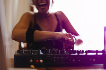 Mittelteil eines fröhlichen weiblichen DJs, der in einem Aufnahmestudio den Ton mischt - CAVF62184