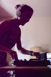 Lächelnder weiblicher DJ, der im Aufnahmestudio stehend Ton mischt - CAVF62191