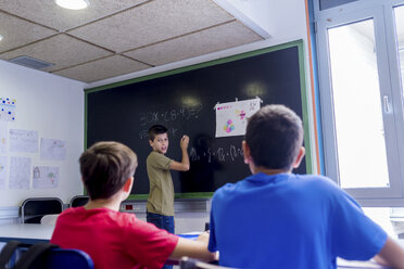 Junge erklärt seinen Freunden im Klassenzimmer Mathematik - CAVF62195