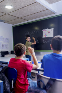 Junge erklärt seinen Freunden im Klassenzimmer die Mathematik - CAVF62196