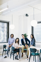 Portrait of smiling business people sitting in creative office - CAVF62280