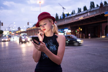 Hipster-Frau schreibt eine SMS auf der Straße, Berlin, Deutschland - CUF49298