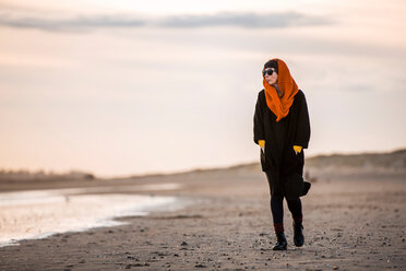 Woman walking alone on beach - CUF49349