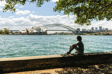 Australien, New South Wales, Sydney, Mann schaut auf die Brücke und das Opernhaus von Sydney - KIJF02347