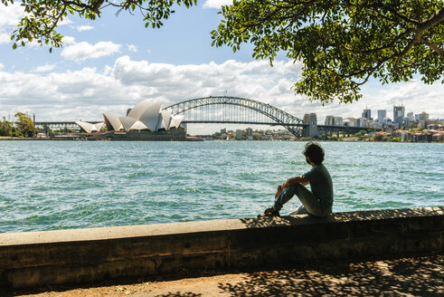 Australien, New South Wales, Sydney, Mann schaut auf die Brücke und das Opernhaus von Sydney - KIJF02347