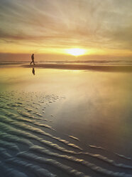 Belgien, Flandern, Nordseeküste, Mann spaziert am Gezeitenbecken entlang und beobachtet den Sonnenuntergang und die Meereswellen, hört den Meeresgeräuschen zu - GWF05905