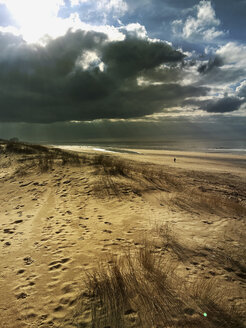 Belgien, Flandern, Nordsee, Strand und Dünen mit Sonnenstrahlen bei Gewitter - GWF05920