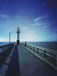 Belgien, Flandern, Nordsee, Küste, Mann, entspannend, auf dem Steg mit Leuchtturm stehend, auf das Meer schauend und dem Meeresrauschen lauschend - GWF05927