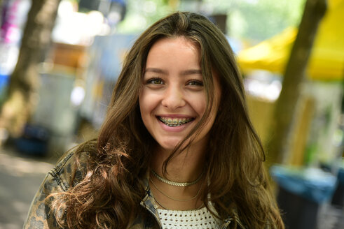 Portrait of laughing teenage girl wearing braces - MIZF00796