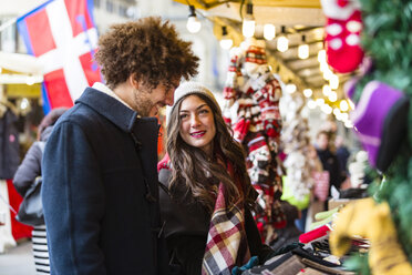 Glückliches junges Paar auf dem Weihnachtsmarkt - MGIF00300