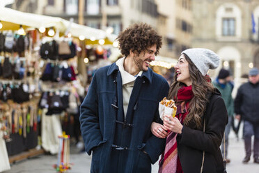 Glückliches junges Paar schlendert über den Weihnachtsmarkt - MGIF00302