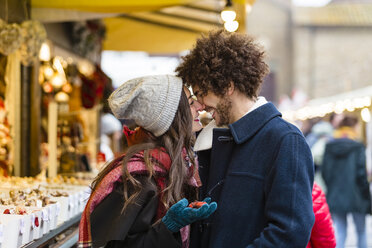 Glückliches, zärtliches junges Paar auf dem Weihnachtsmarkt - MGIF00304